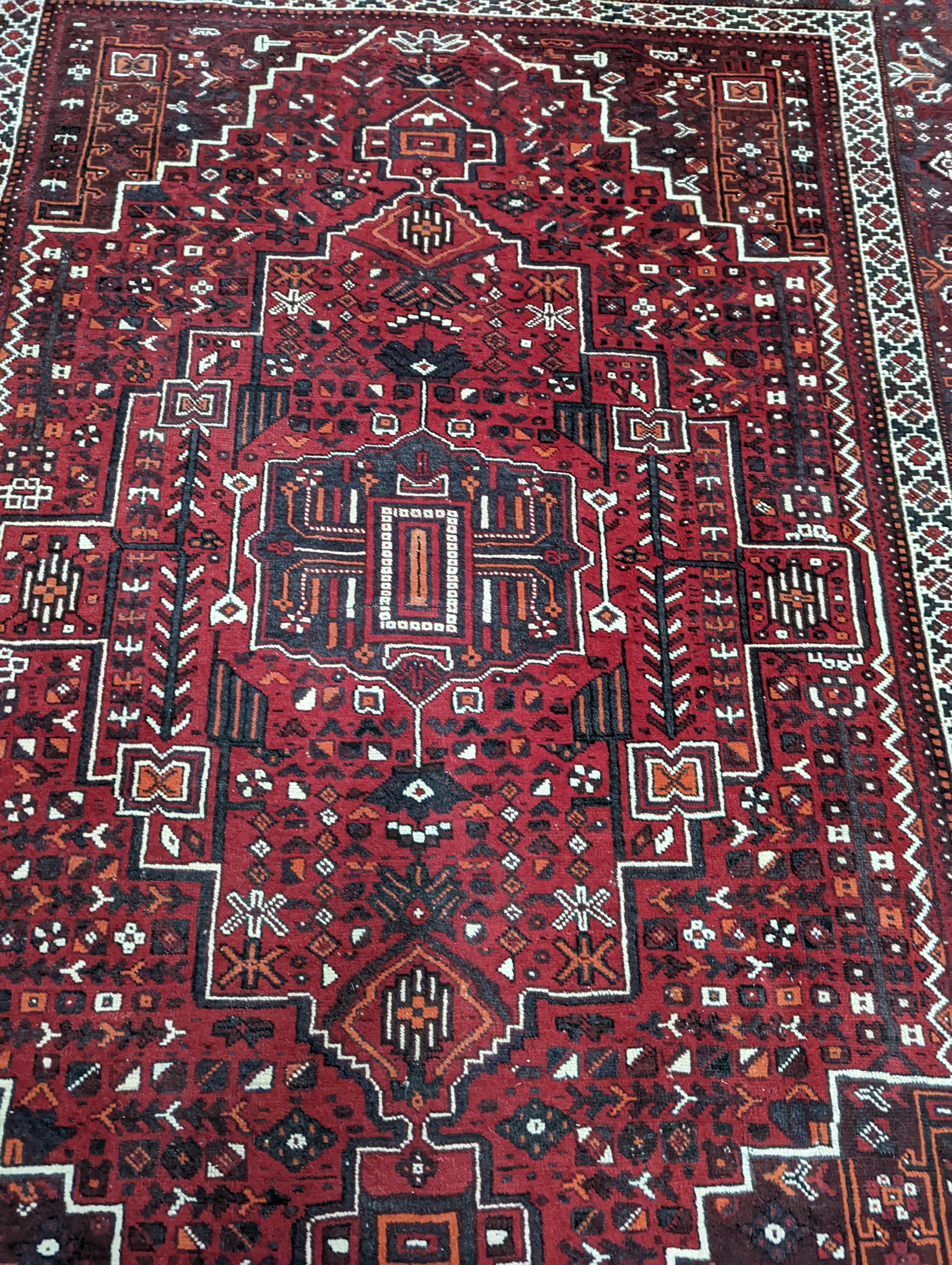 A Caucasian design burgundy ground carpet, 280 x 210cm